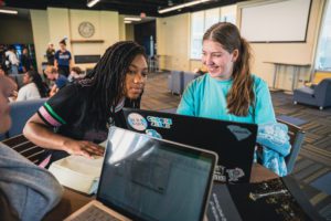 Three girls studying at a table together in the Little John Parlor