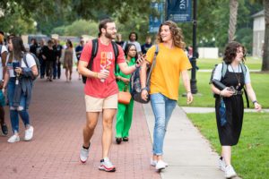 Two boys walking to chapel while talking to each other and other students in the background