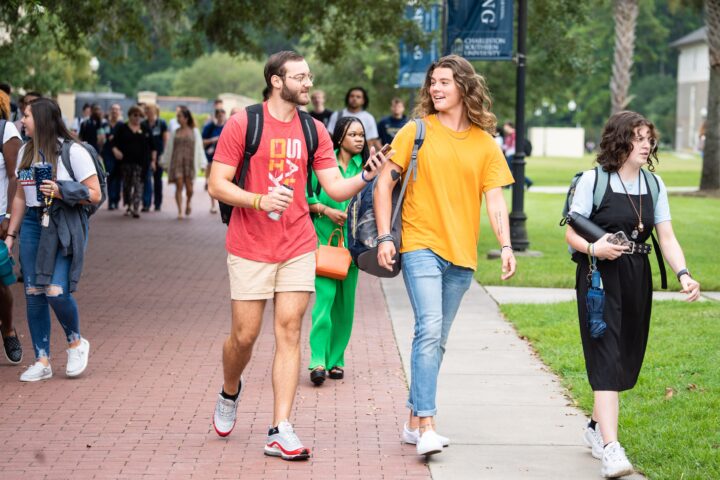 Two boys walking to chapel while talking to each other and other students in the background