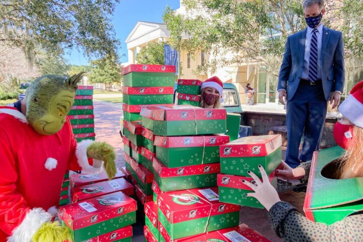 President Dondi Costin assists with transporting donated Operation Christmas Child shoeboxes at Charleston Southern University