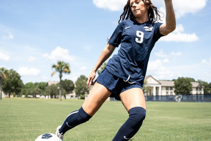 A girl from the Women's soccer team (number 9) shooting the ball