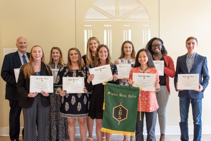 Mutliple people receiving their Sigma Beta Delta diploma