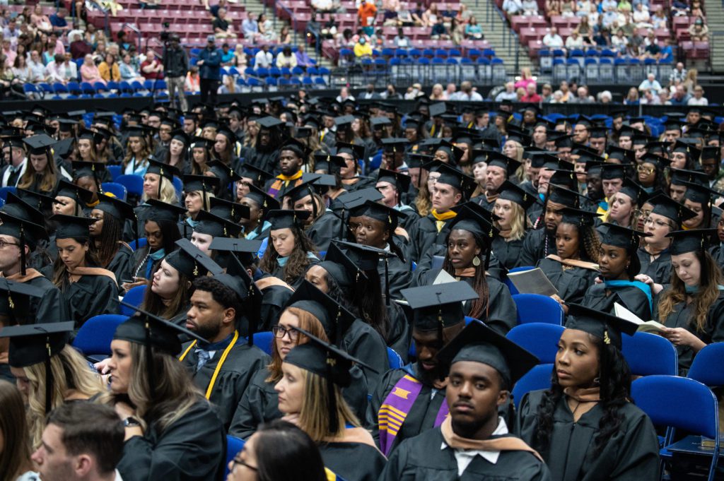 Multiple students excited to recieve their diploma at the graduating ceremony