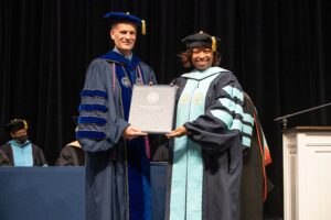 Dr. Tammy Thompson accepts her diploma from President Dr. Dondi Costin
