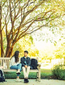 Boy and girl student sitting on bench.