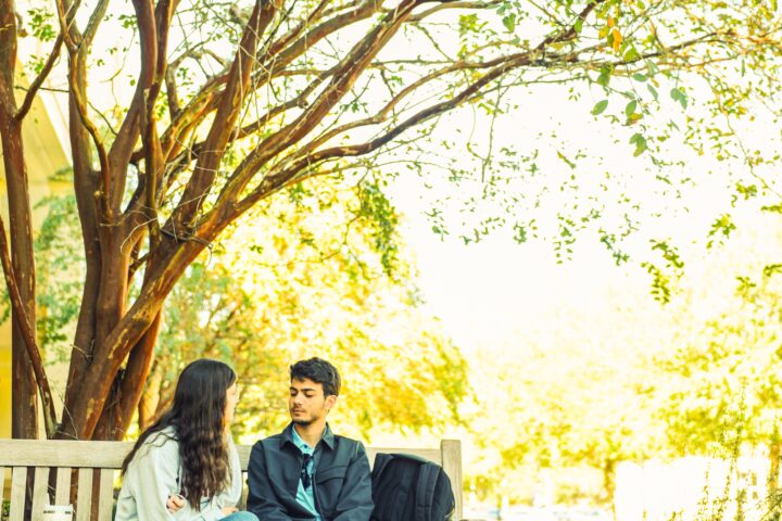 Boy and girl student sitting on bench.