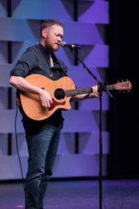 Andrew Peterson playing guitar during Chapel.