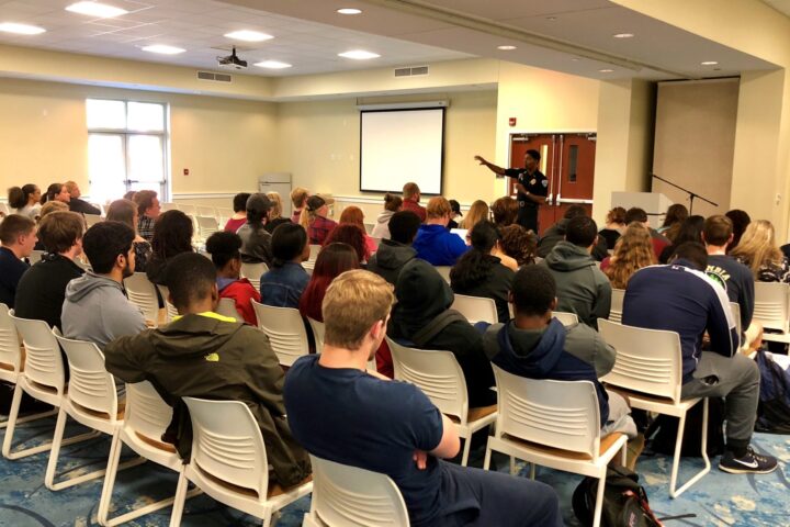 Reggie Burgess speaking to a room of college students.