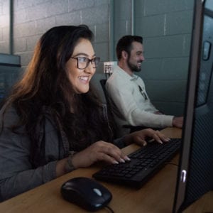 Two students who look interested in what is on their computer screen.