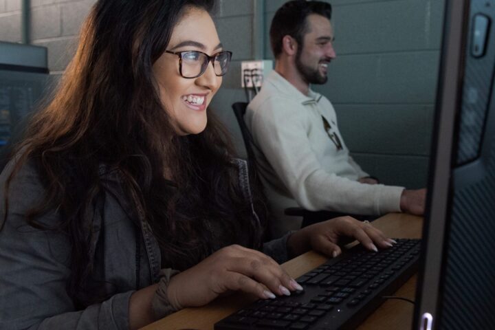 Two students who look interested in what is on their computer screen.
