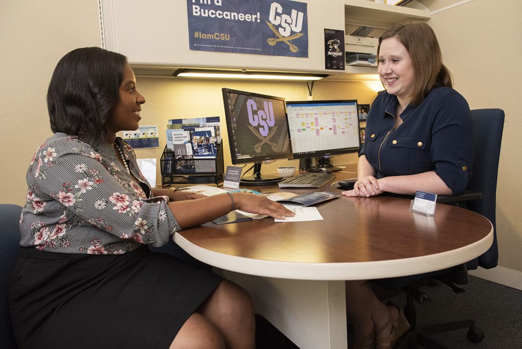 A student sitting down with an admissions counselor