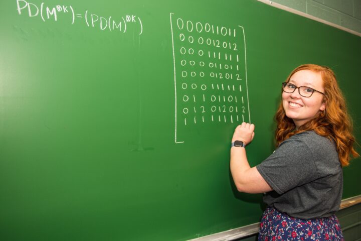 Maddy Parsons writing on a chalkboard