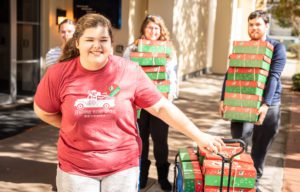 A few students grabbing boxes to fill them with toys for children