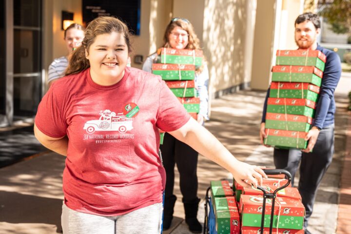 A few students grabbing boxes to fill them with toys for children