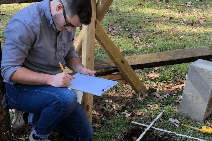 Ethan Shuler documents layout of new dig site in internship