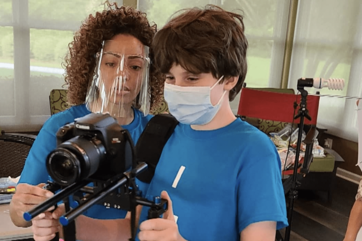 Ashley Drayton assists an artist at Camp Artism with videography