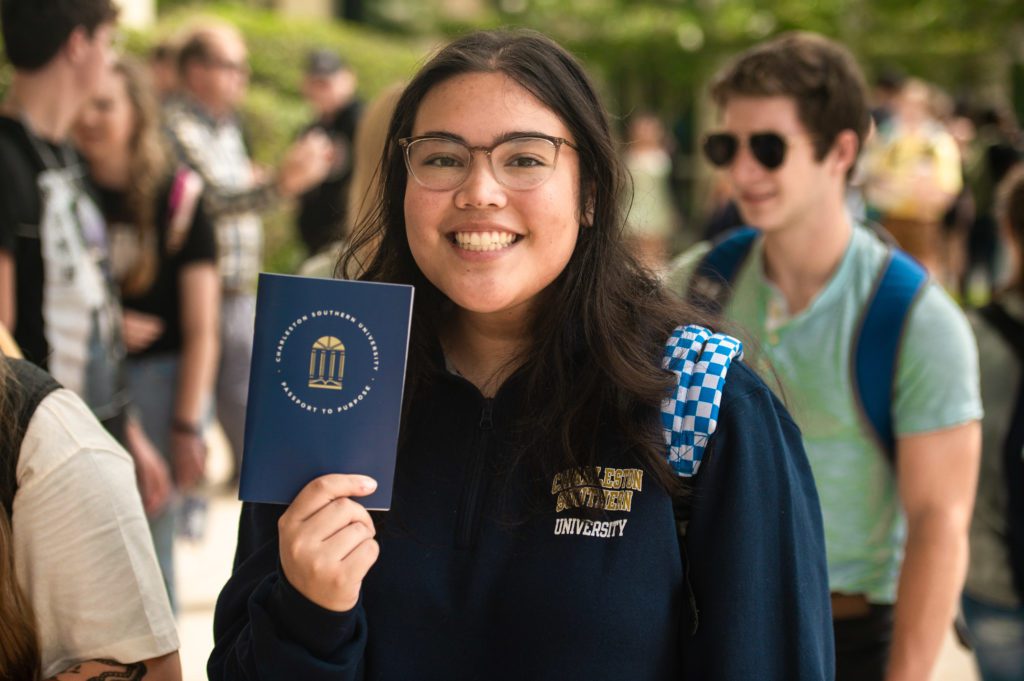 A girl holding a CSU passport- a newsletter graphic