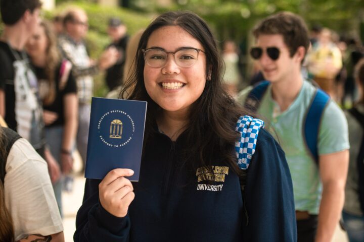 A girl holding a CSU passport- a newsletter graphic