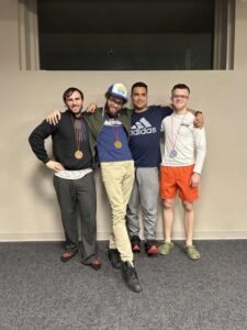 Four students at the esports club taking a picture together with their medal around their neck