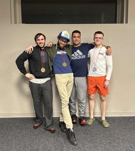Four students at the esports club taking a picture together with their medal around their neck