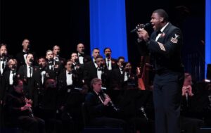 A Navy member singing at a formal event.