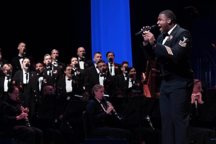 A Navy member singing at a formal event.